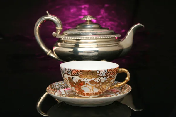 Silver teapot and an antique chinese cup of tea — Stock Photo, Image