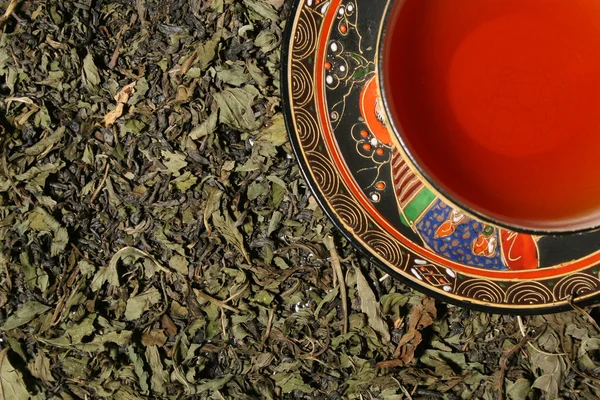 Théière en argent versant le thé dans une tasse chinoise — Photo