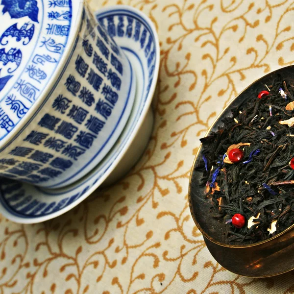 Théière en argent versant le thé dans une tasse chinoise — Photo