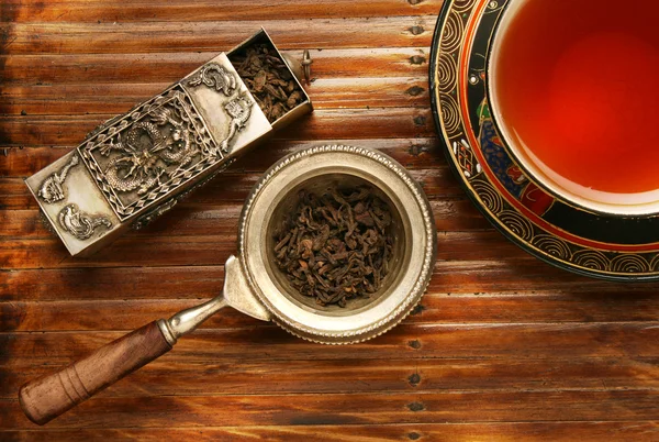 Антикварная китайская чашка и смесь чайных листьев — стоковое фото