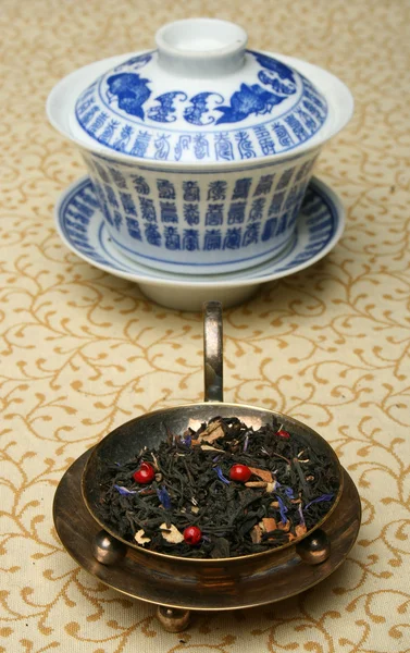 Антикварная китайская чашка и смесь чайных листьев — стоковое фото