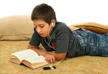 Boy reading and listening music clipart