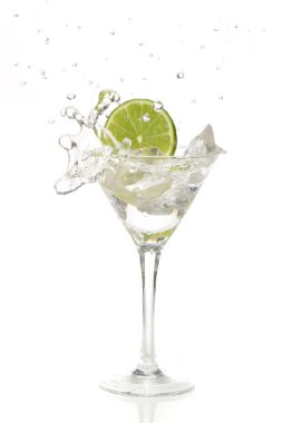 Lime splashing into a cocktail glass clipart