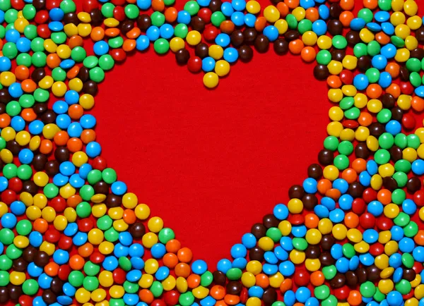 White heart shape with candy background — Zdjęcie stockowe