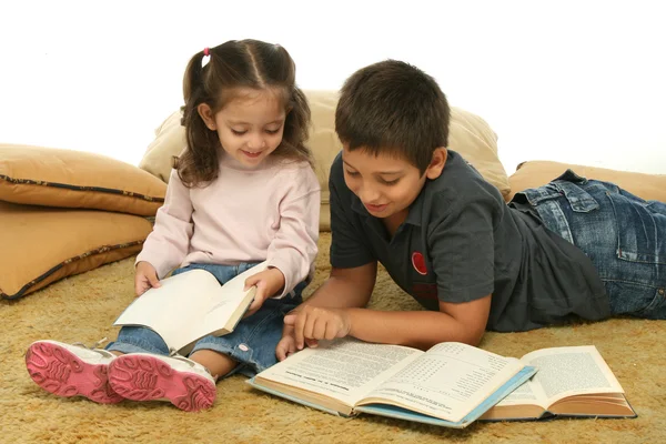 Irmão e irmã lendo livros no chão — Fotografia de Stock