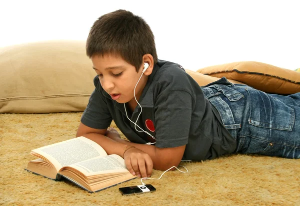 Junge liest und hört Musik — Stockfoto