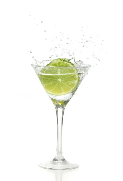 Lime splashing into a cocktail glass — Stock Photo, Image