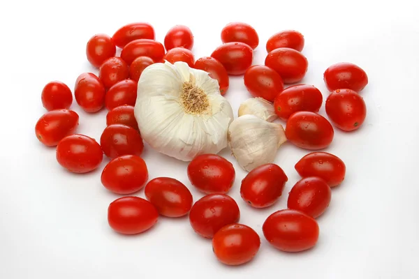 Česnek, obklopené cherry rajčátky — Stock fotografie