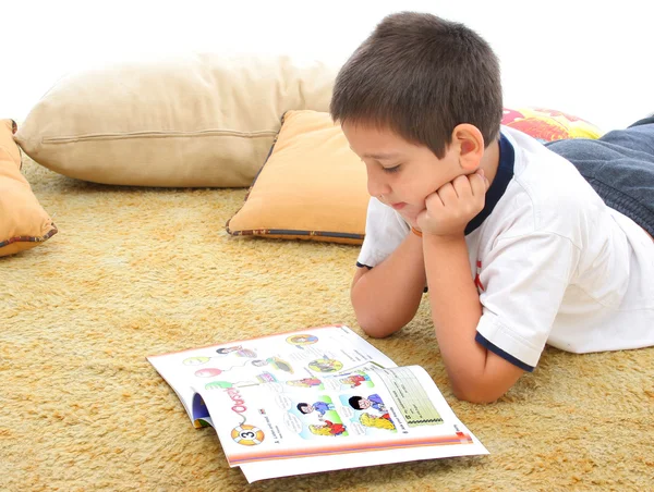 Мальчик читает книгу на полу — стоковое фото