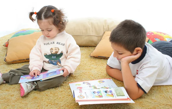 Брат и сестра читают книги на полу — стоковое фото