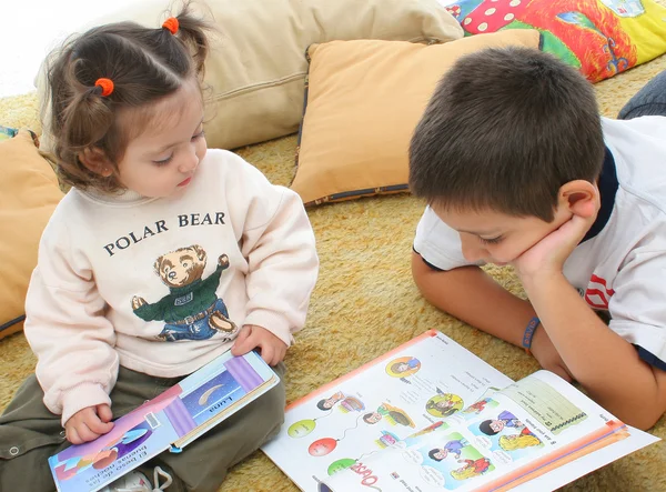 Брат і сестра читають книги на підлозі — стокове фото