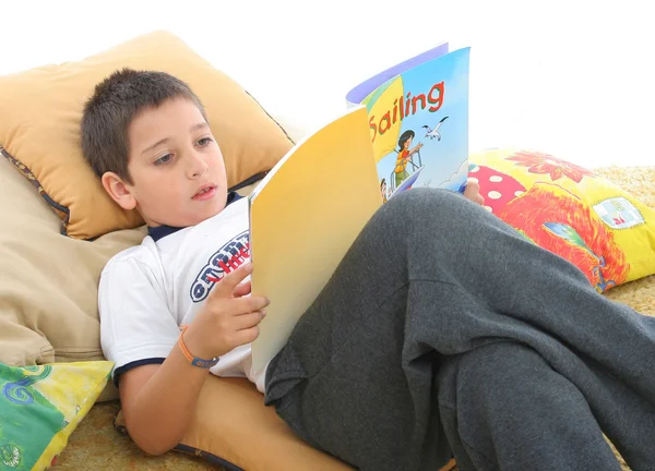 Pojke läser en bok på golvet — Stockfoto