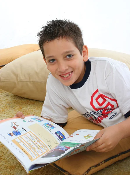 Junge liest ein Buch auf dem Fußboden — Stockfoto