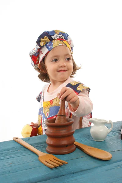 Маленькая девочка готовит еду в костюме повара — стоковое фото