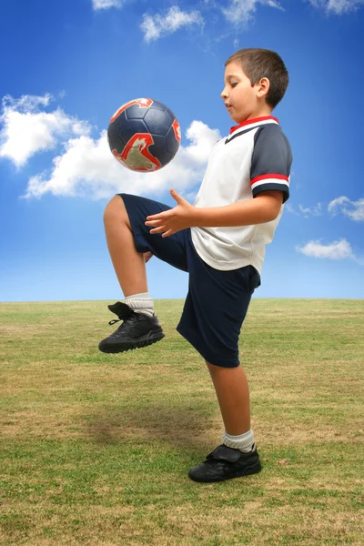 Ребенок играет в футбол снаружи — стоковое фото