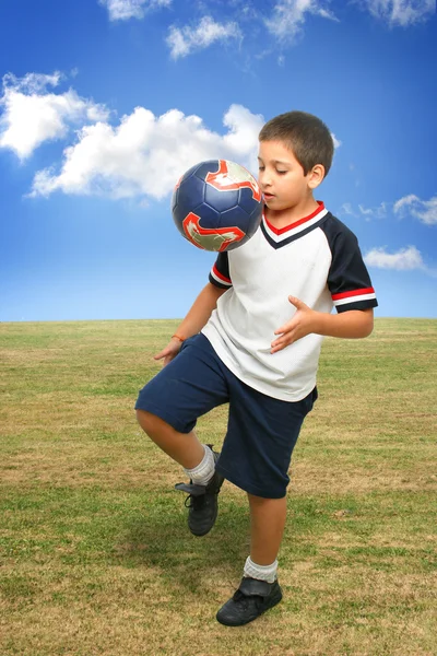 Miúdo a jogar futebol lá fora — Fotografia de Stock