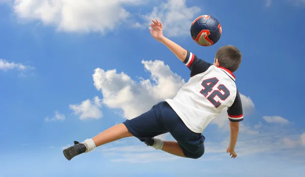 Dziecko grając w piłkę nożną poza — Zdjęcie stockowe