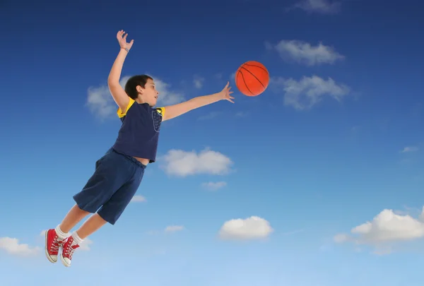 Мальчик играет в баскетбол прыжки и полеты — стоковое фото