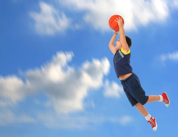 Menino jogando basquete pulando e voando — Fotografia de Stock