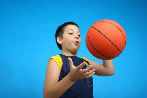 打篮球的男孩。蓝色背景 — 图库照片