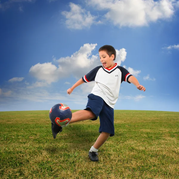 Kid hrát fotbal mimo Stock Obrázky