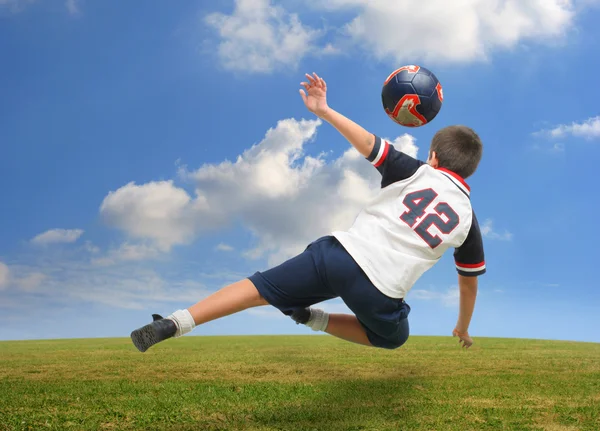 Kid hrát fotbal mimo Stock Fotografie