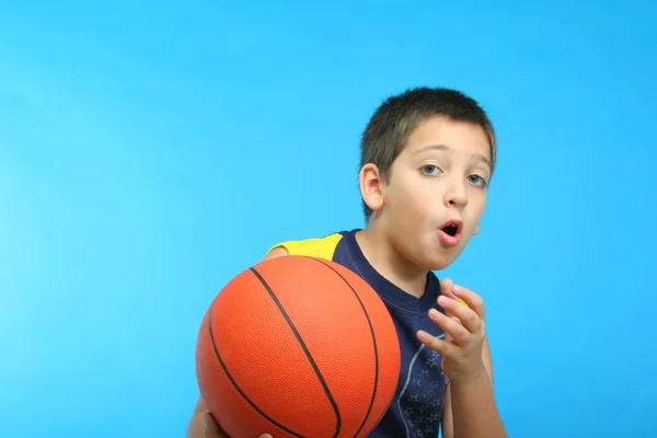 Chlapec hrát basketbal. modré pozadí — Stock fotografie