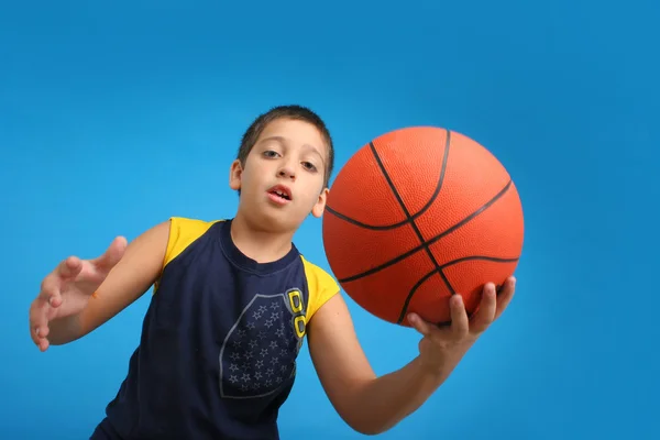 Rapaz a jogar basquetebol. fundo azul — Fotografia de Stock