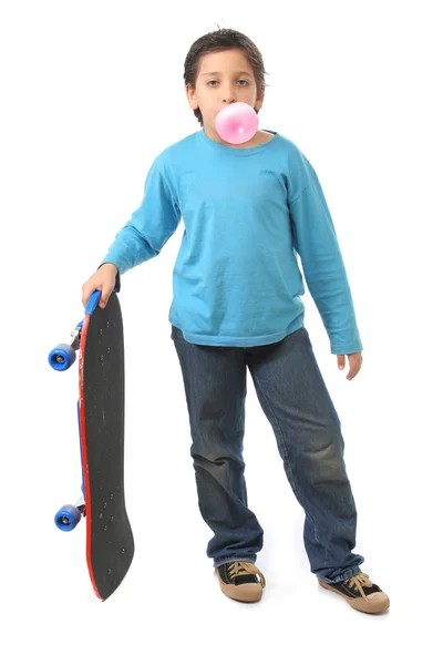 Pojken blåser ett tuggummi som innehar en skridsko — Stockfoto
