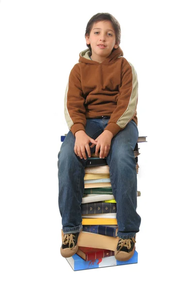 Студент сидит на стопке книг — стоковое фото