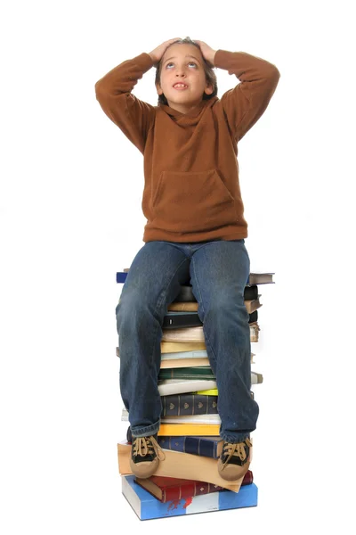 Студент сидит на стопке книг — стоковое фото