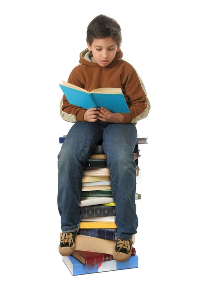 Student sitzt auf einem Stapel Bücher — Stockfoto