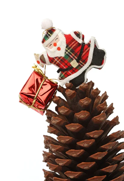 Santa com caixa de presente sobre um cone de pinho — Fotografia de Stock