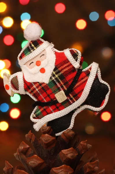 Père Noël avec boîte cadeau sur un cône de pin — Photo