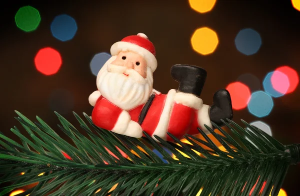Papai Noel descansando sobre uma árvore de ramos de Natal — Fotografia de Stock
