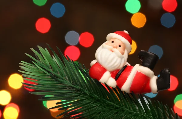 Santa descansando sobre un árbol de ramas de Navidad — Foto de Stock