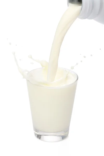 Bottiglia versando il latte in un bicchiere. Spruzzi — Foto Stock