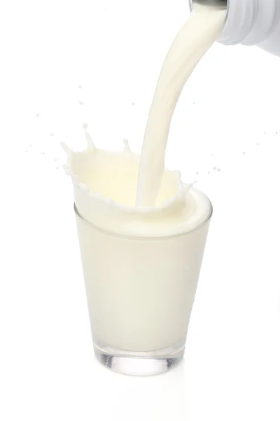 Botella vertiendo leche en un vaso. Salpicadura — Foto de Stock