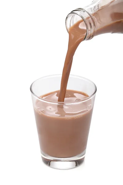 Garrafa derramando chocolate de leite em um copo — Fotografia de Stock