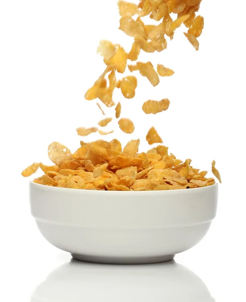 Menuang cornflakes ke dalam mangkuk, atas latar belakang putih — Stok Foto