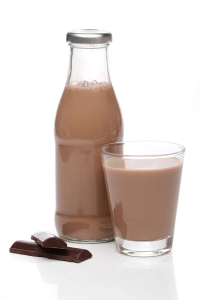 Şişe ve bardak beyaz zemin üzerine çikolatalı süt — Stok fotoğraf