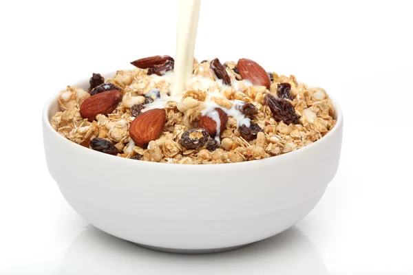 Menuang susu ke dalam mangkuk dengan sereal granola — Stok Foto