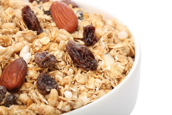 Primer plano de cereal de granola en un tazón, sobre fondo blanco — Foto de Stock