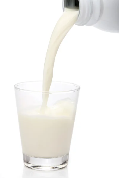 Garrafa derramando leite em um copo. Espirro — Fotografia de Stock