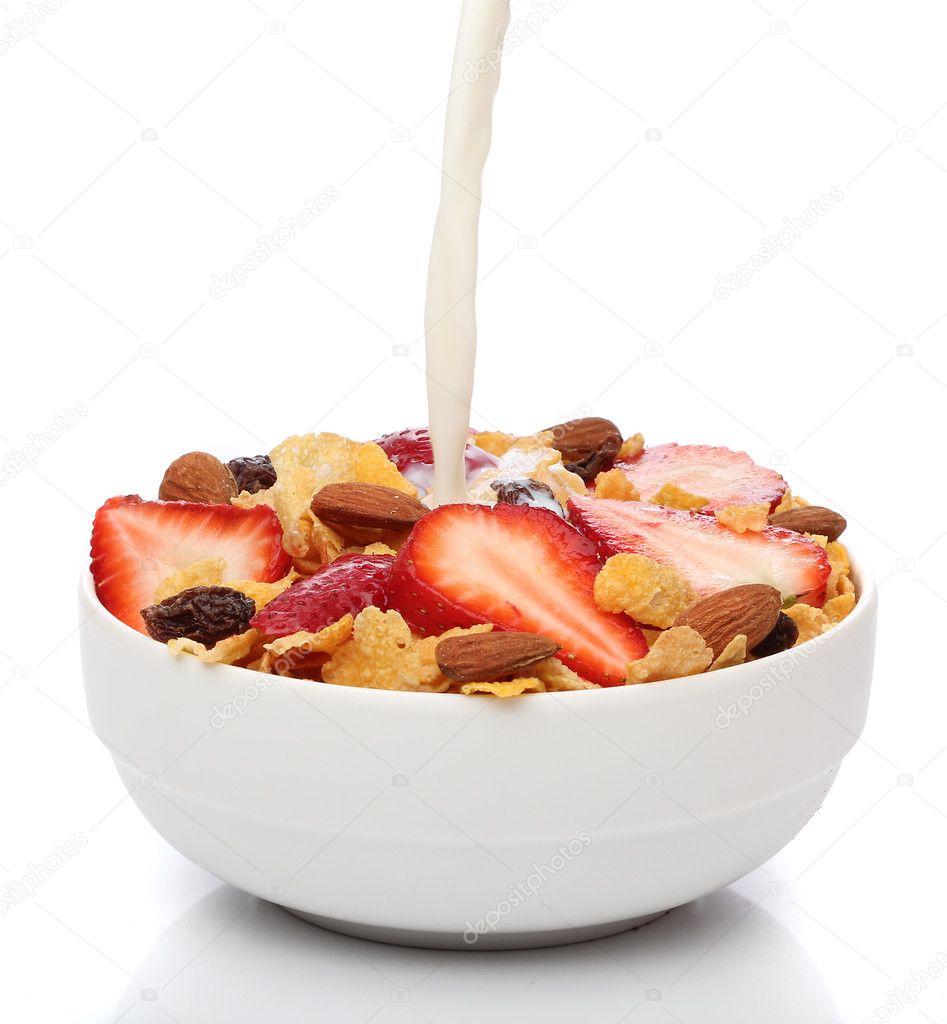 Pouring milk into a bowl of cornflakes and fruits