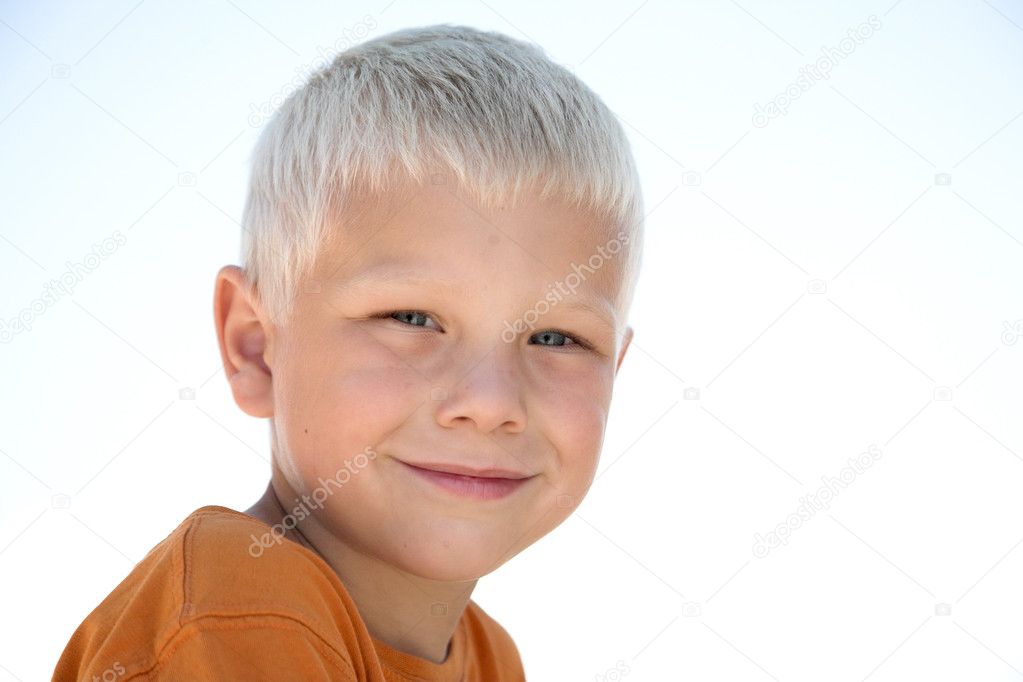 Young blonde kid smiles in orange shirt