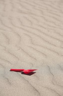 kum örgüler ve kırmızı plastik kürek