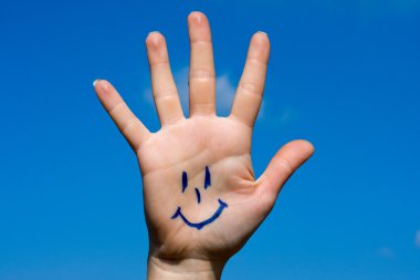 Human palm with smile on sky background clipart