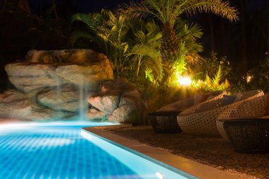 Luxury resort with pool at night view clipart