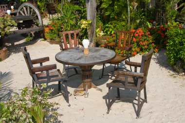 Table and chairs in a tropical garden clipart